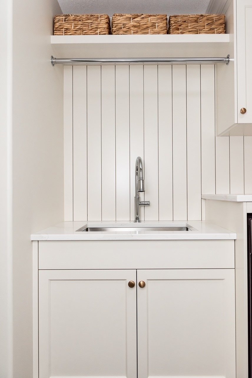 Laundry millwork sink with beadboard and hanging rail