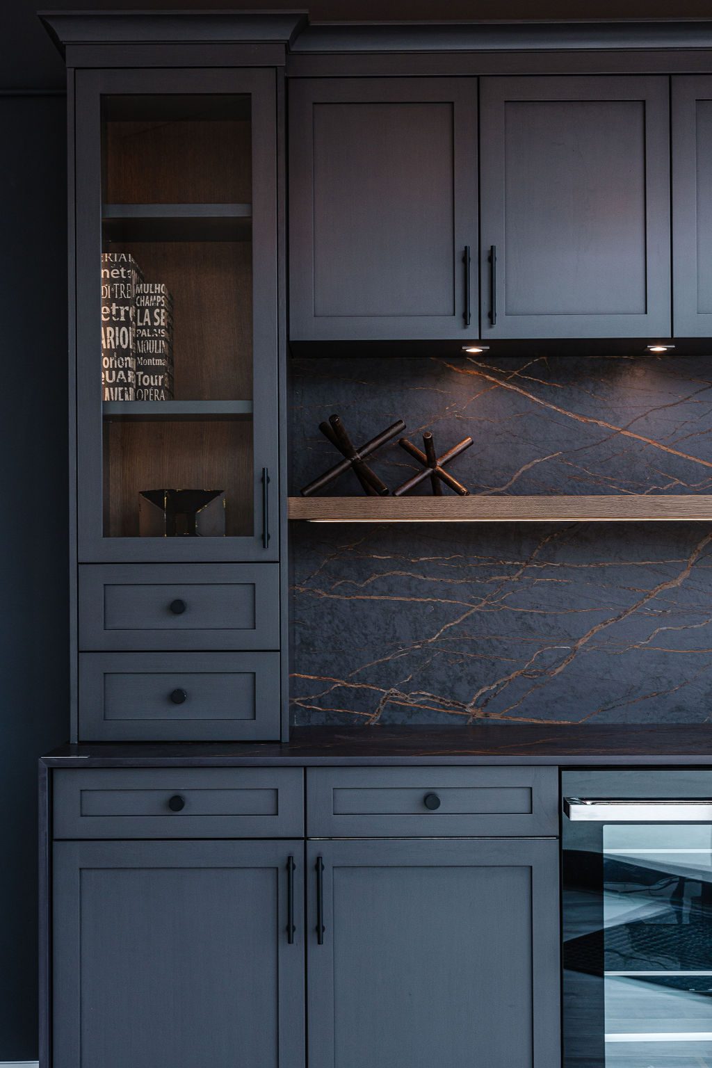 Dark millwork bar with stone backsplash